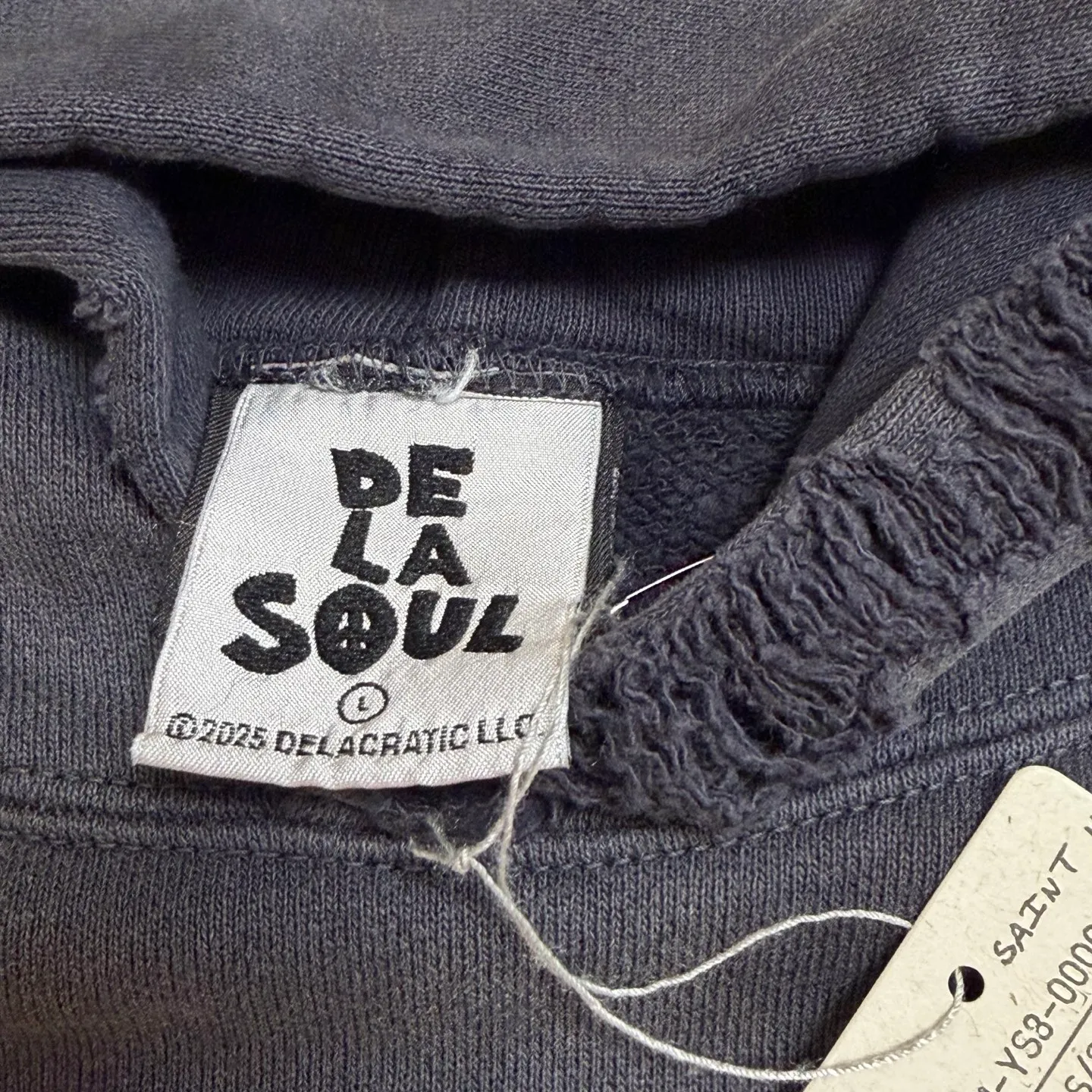 More details SAINT Mxxxxxx × DE LA SOUL DLS_HOODIE/DE LA SOUL/BLK DE LA SOUL co-branded potted plant destruction hoodie, washed black S-XL, a very important hoodie this season. It embodies the brand philosophy through the humorous potted plant and slogan design. In addition, through a large number of hand-made fraying, cutting and other destruction processing, as well as heavy washing and oxidative fading treatment, it creates a perfect vintage effect. Original mold opening Customized co-branded main mark and wash water mark, correct version
